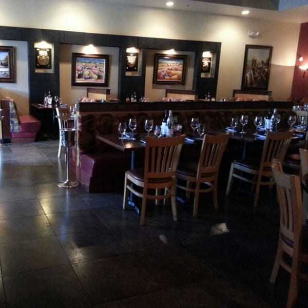 El Chaman Peruvian Cuisine dining room with set tables, booth seating, and Peruvian artwork on the walls.